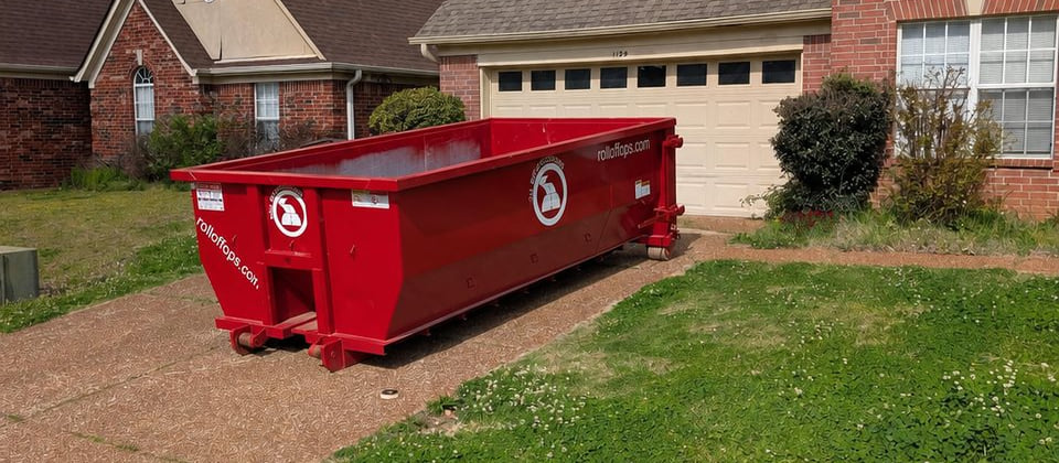 Red 15-yard Roll Off Operations dumpster positioned on a residential driveway